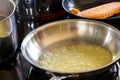 An induction cooker with some stainless steel pans and pots on them. One of the pans has molten fizzy butter in it, so the cook Royalty Free Stock Photo