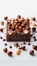 Indulge in allure brownie slice with hazelnuts on white canvas Royalty Free Stock Photo