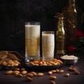 Creamy and nutty Badam Milk in a tall glass with sweet pastries on table Royalty Free Stock Photo