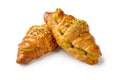 Two overlapping croissants with pistachio cream on a white background