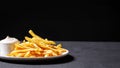 a plate with fries served with white tartar sauce on a black background, Generated AI