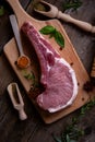 Indulge in the rustic charm of a raw piece of pork loin on a wooden board