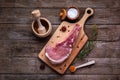 Indulge in the rustic charm of a raw piece of pork loin on a wooden board