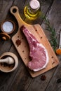 Indulge in the rustic charm of a raw piece of pork loin on a wooden board
