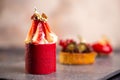 Three fancy desserts with berries on a gray slate board against a mottled pink background Royalty Free Stock Photo