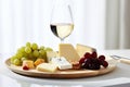 Indulgent Delights. Starter Selection, Cheese Plate, Grapes, and White Wine for Solo Pleasure Royalty Free Stock Photo