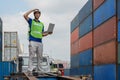 Industrail background of caucasian containers yard and cargo inspector with laptop computer on hand working at containers loading Royalty Free Stock Photo