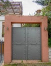 An industrial aesthetics, dark grey painted iron door with a pale orange frame.