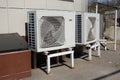 Industrial air conditioner condensers outdoor unit on the ground near the building on a hot summer day Royalty Free Stock Photo