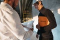 Two building engineers lookin at blueprint on construction site Royalty Free Stock Photo