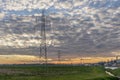 An industrial area crossed by the high voltage line under a dramatic sky just before sunset Royalty Free Stock Photo