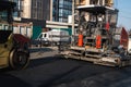 Industrial asphalt paver machine laying fresh asphalt and a Heavy road roller with vibration roller compactor press new Royalty Free Stock Photo