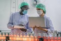 Production line supervisor and worker work together in beverage production line Royalty Free Stock Photo