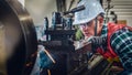 Industrial background of caucasian mechanics engineer operating lathe machine for metalwork in metal work factory