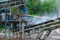 Industrial background - crusher rock stone crushing machine at open pit mining and processing plant for crushed stone, sand and Royalty Free Stock Photo