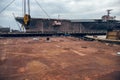 Industrial background of rusty metal platform in the dock port with battleship
