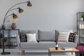 Industrial lamp above stylish grey couch , real photo with copy space