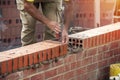 Industrial bricklayer laying bricks on cement mix o