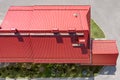 Industrial building from above. red metal roof with installed pipes of ventilation systems