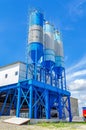 Industrial building with big blue tanks for cement, sand, water. Metal stairs leading to metal containers. Vertical photo Royalty Free Stock Photo