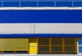 Industrial building with blue and yellow metal siding trim. Abstract background Royalty Free Stock Photo