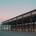 An industrial building with a long, open metal framework and support columns. The Royalty Free Stock Photo