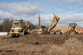 Industrial bulldozer and truck moving earth on a construction site