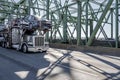 Industrial car hauler big rig gray semi truck transporting cars on modular semi trailer running on the truss Interstate Columbia