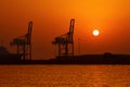 Industrial cargo port and silhouette of cranes at sunset int Dubai Royalty Free Stock Photo