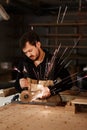 Industrial carpenter worker cutting metal with many sharp sparks at a work bench in a carpentry workshop. Selection focus to