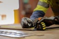 Industrial carpentry wearing a safety glove holding a selt retractable tape measurement while conducting measuring mark Royalty Free Stock Photo