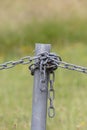 Industrial chain attached to a galvanised fence post Royalty Free Stock Photo