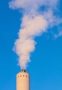 An industrial chimney exhausting white smoke