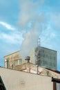 Industrial chimney fume and steam exhaustion on old factory building
