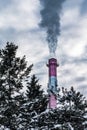 Industrial chimneys with dramatic smoke in nature on cold winter day