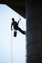 Rope access technician checking the lanyard on concrete bridge pillar Royalty Free Stock Photo