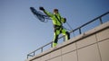 Industrial climber throws rope down from roof of building