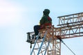 Industrial climber in uniform sitting ts on a building structure