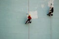 Industrial climbers paint the wall of the building