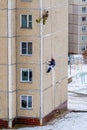 Industrial climbers repair the joints between the panels of an apartment building