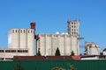 Industrial complex multiple tall concrete storage silos with cell phone antennas and transmitters on top surrounded with dark