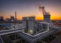 Industrial complex at sunset featuring large cooling towers and an Royalty Free Stock Photo