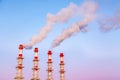 Industrial concept. Smoking chimneys or factory pipes against the blue twilight sky