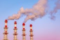 Industrial concept. Smoking chimneys or factory pipes against the blue twilight sky