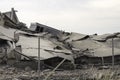 Industrial concrete building destructed by strike. Disaster scene full of debris, dust and crashed buildings Royalty Free Stock Photo