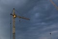 Industrial construction building crane against grey cloudy sky Royalty Free Stock Photo
