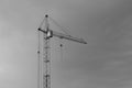 Industrial construction building crane against grey cloudy sky Royalty Free Stock Photo