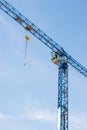 Industrial construction crane hoisting against blue sky