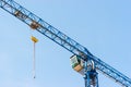 Industrial construction crane hoisting against blue sky