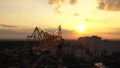 Industrial construction cranes and building silhouettes over sunset background and sunrise